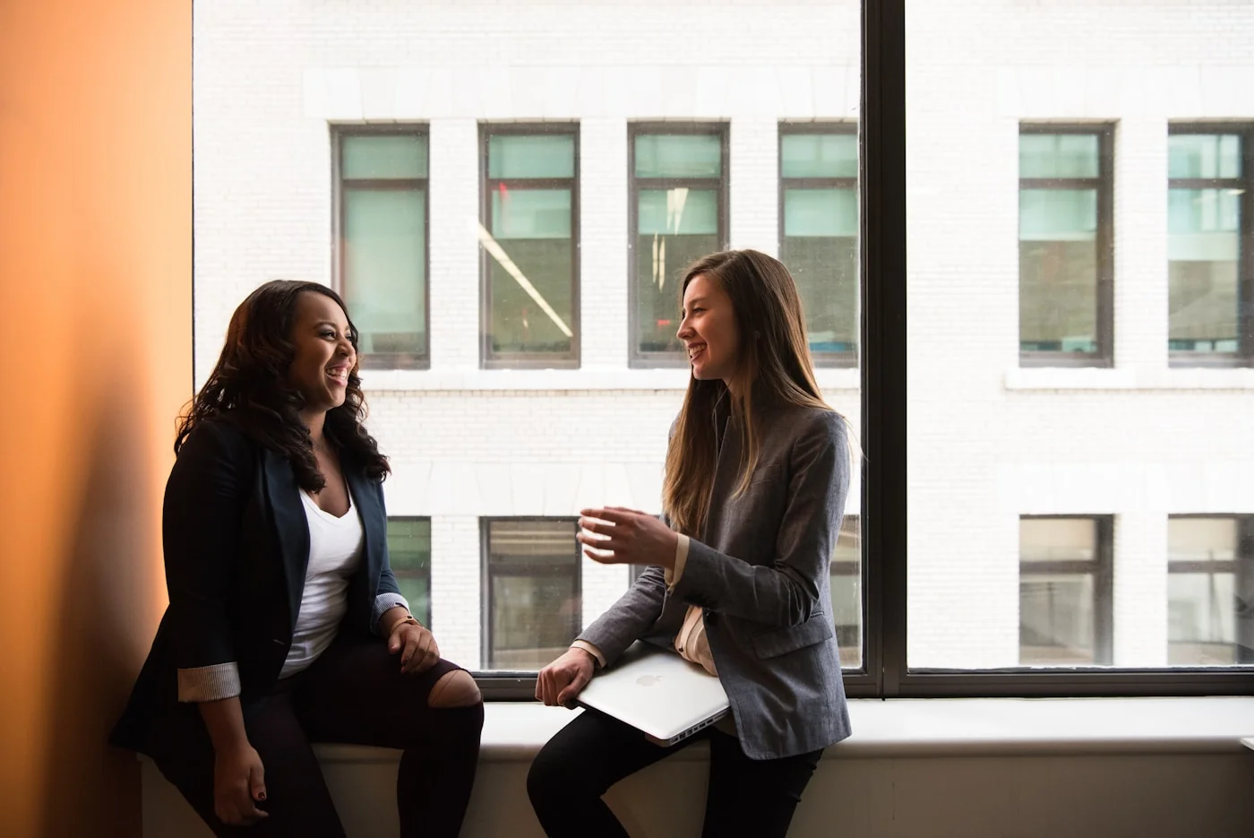 Colleagues talking together beside an office window